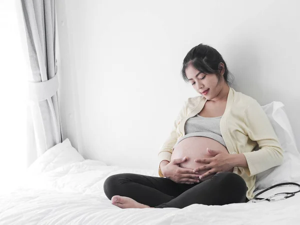 Молодая Азиатская Беременная Женщина Трогает Живот Сидит Кровати Концепция Образа — стоковое фото