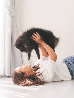 Yerde yatarken ve dokunaklı onun siyah köpek, yaşam kavramı mutlu Asyalı kadın.