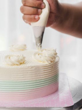 Bir hamur işi çanta kullanarak kremalı kek Tepesi pudra,