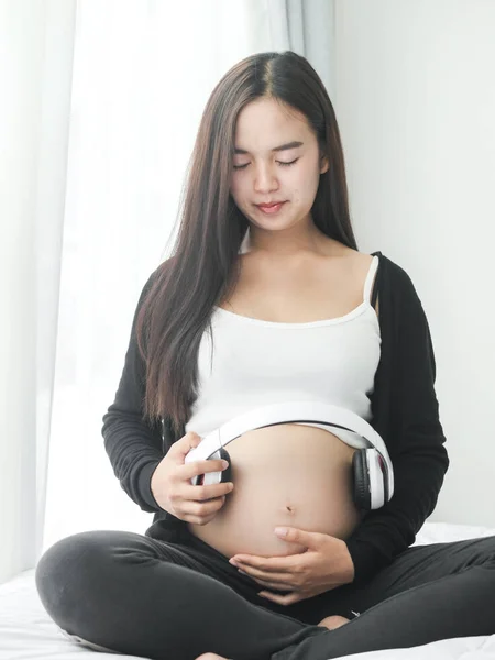 Schöne Asiatische Schwangere Frau Mit Kopfhörer Auf Dem Bauch Hause — Stockfoto