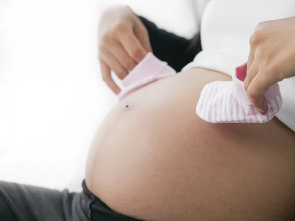 Zwangere Vrouw Handen Met Roze Sokken Haar Buik Lifestyle Concept — Stockfoto