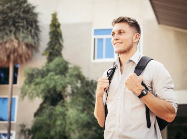 Sırt çantası ayakta önünde binanın dışında eğitim kavramı ile mutlu Üniversitesi öğrenci.