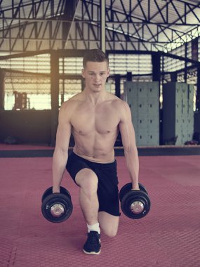 Yakışıklı mandoing dumbbells ile egzersizleri.