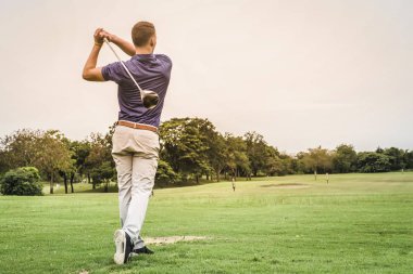 Yeşil alan kopya alanı ile topa vurmak golfçü arkası.