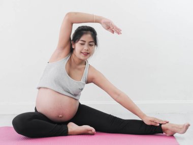 Evde yoga yaparken Asyalı hamile kadın yaşam tarzı kavramı.