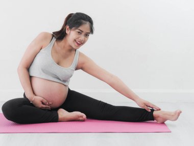 Evde yoga yaparken Asyalı hamile kadın yaşam tarzı kavramı.