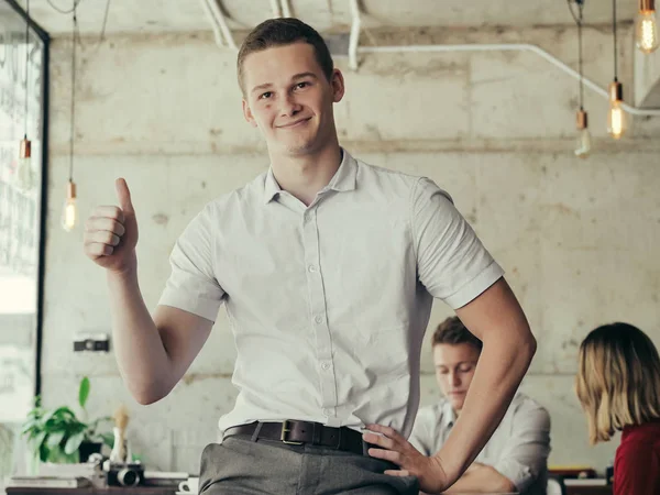 拇指上的成功的年轻商人启动 交叉手臂和微笑在工作场所 — 图库照片
