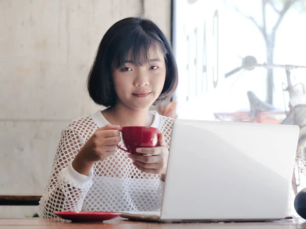 Glad Asiatisk Tonåring Flicka Håller Varm Dryck Handen Medan Arbetar — Stockfoto