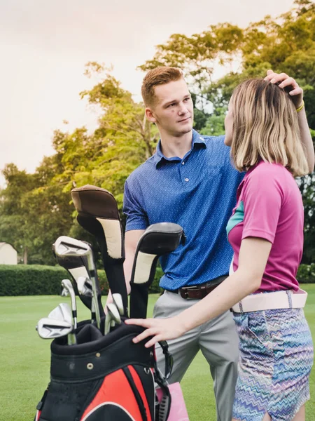 男高尔夫球手触摸他的女朋友的头发与爱 生活方式的概念 — 图库照片