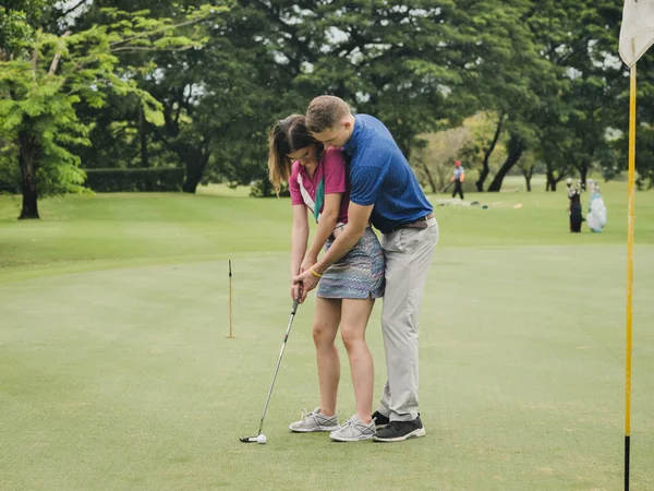 高尔夫教授他的女朋友打高尔夫 生活方式的概念 — 图库照片