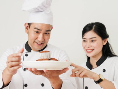 Cupcakes beyaz plaka üzerinde tutarak ve daha önce kontrol pasta şefi hizmet.