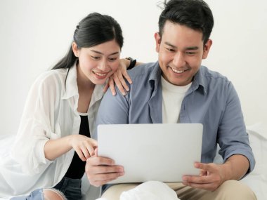 Evde, dizüstü bilgisayar kullanarak mutlu Asya Çift yaşam tarzı kavramı.