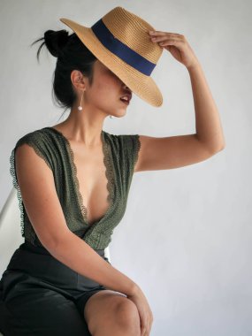 Yüzünü gizleme şapka giymiş güzel Asyalı kadın portresi.