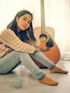 Asyalı kadın yaşam tarzı kavramı iskambil gitar ve şarkı bir şarkı evde,.