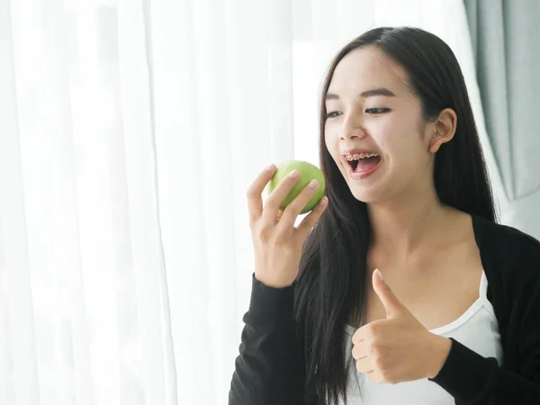 Felice Donna Asiatica Mangiare Mela Verde Vicino Alla Finestra Casa — Foto Stock