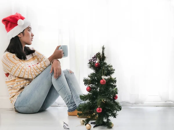 Asiatin Mit Weihnachtsmütze Und Kaffeetasse Und Blick Aus Dem Fenster — Stockfoto