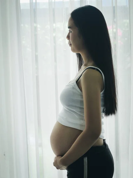 Азиатская Беременная Женщина Трогает Живот Окна Концепция Образа Жизни — стоковое фото
