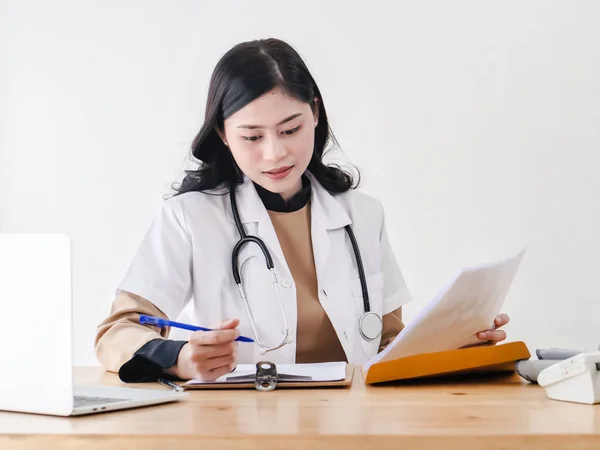 Female Asian doctor working at office desk, lifestyle concept.