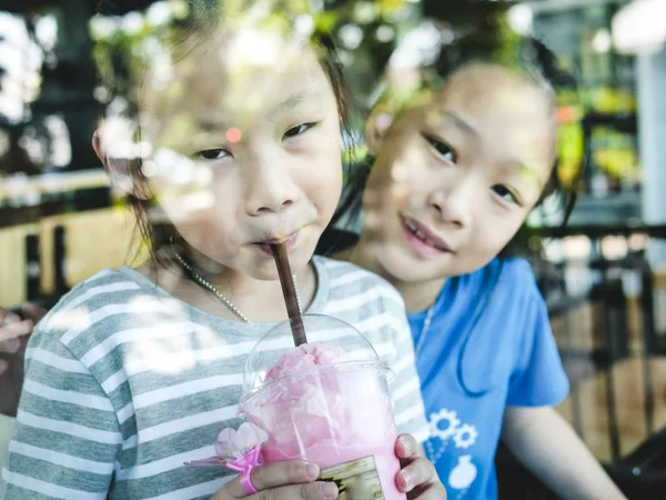 ハッピー アジア子供ライフ スタイル コンセプトのコーヒー ショップでのドリンクをお楽しみください — ストック写真