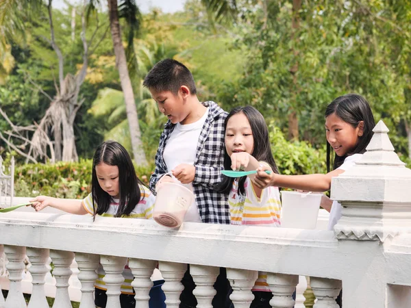 Niños Asiáticos Felices Alimentando Peces Lago Aire Libre Concepto Estilo —  Fotos de Stock