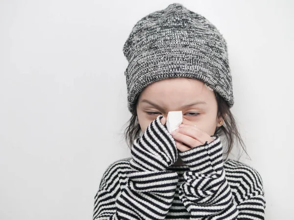 Cute Asian girl using napkin with her snot on white background.