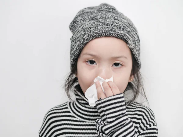 Cute Asian girl using napkin with her snot on white background.