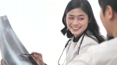 Asyalı doktor ve çocuk hasta birlikte XRAY filmine bakarken.