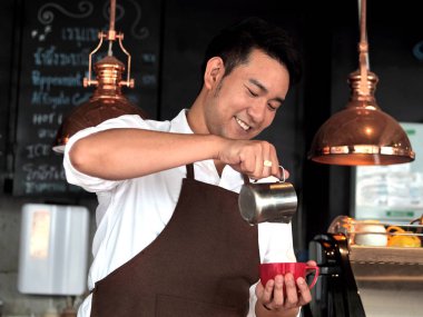 Kafede çalışan mutlu Asya barista adam.
