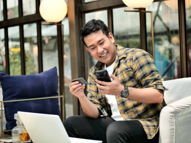 Online banka havalesi yapma, adam bir kredi kartı laptop içinde veri girerken tutar