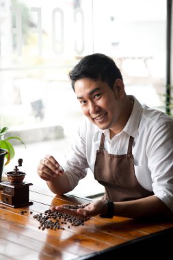 Mutlu Asya barista kahve çekirdekleri taşlama, yaşam kavramı için holding.