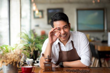 Mutlu Asya barista kahve çekirdekleri taşlama, yaşam kavramı için holding.