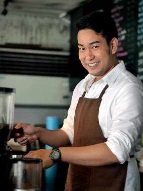 Kafede çalışan mutlu Asya barista adam.