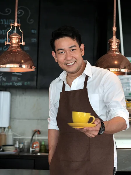 Asya barista hizmet sarı kahve kupa, yaşam kavramı.