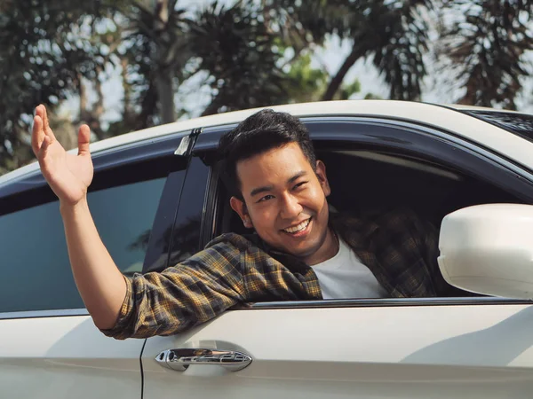 Araba ile şehir arka plan dışarı el yükselterek mutlu Asyalı adam.