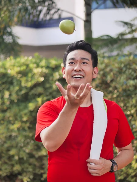 Feliz Asiático Deporte Hombre Lanzando Verde Manzana Mano —  Fotos de Stock