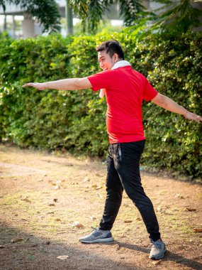 Mutlu Asya spor adam doning egzersiz açık parkta.