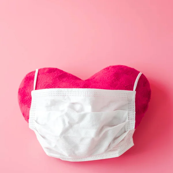 Pembe Kalp Arka Plan Üzerinde Beyaz Koruyucu Yüz Maskesi Boşaltmak — Stok fotoğraf