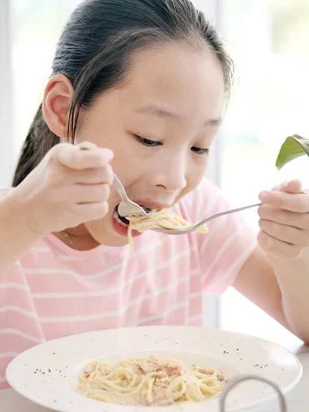 レストランでスパゲティを食べるかわいいアジアの女の子 — ストック写真
