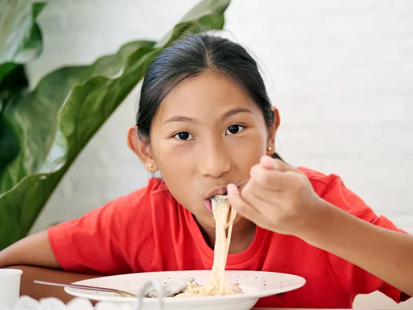 家でスパゲッ ティーを食べて幸せなアジアの女の子 — ストック写真