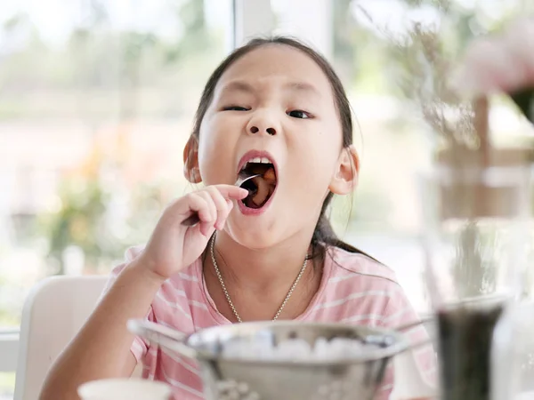 自宅でライフ スタイル概念の窓の近く揚げソーセージを食べるアジアの女の子 — ストック写真