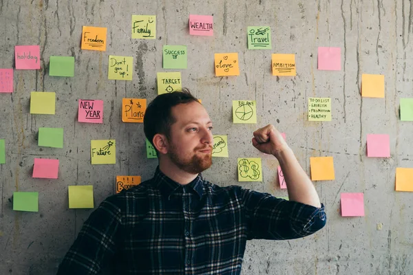 Felice Uomo Alzando Pugno Con Colorato Messaggio Appiccicoso Sfondo Muro — Foto Stock