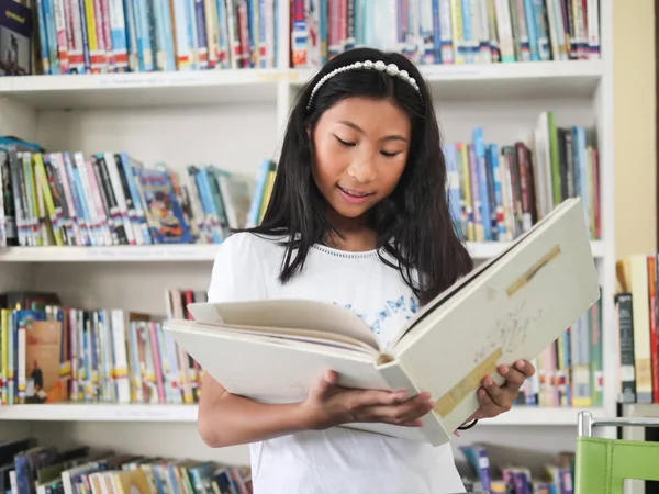 Asiatisk Jente Leser Bok Med Bokhyllebakgrunn – stockfoto