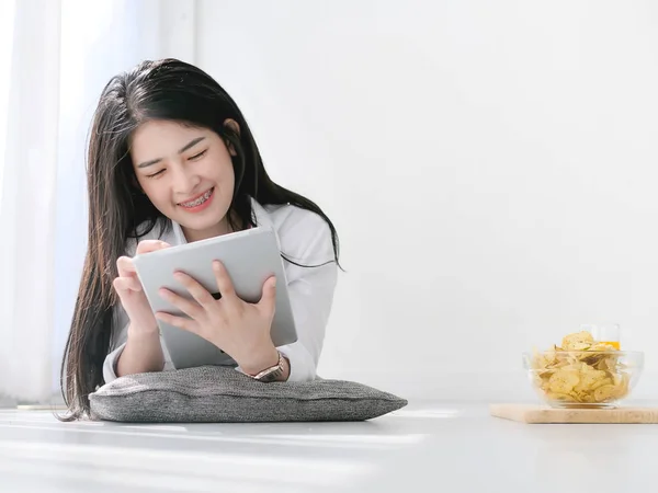 Hermosa joven mujer asiática vistiendo camisa blanca y usando tableta — Foto de Stock