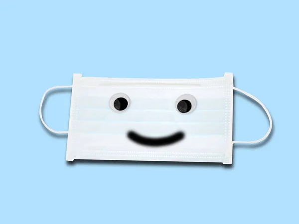 Happy face on Protective white face mask on blue background. — Stock Photo, Image