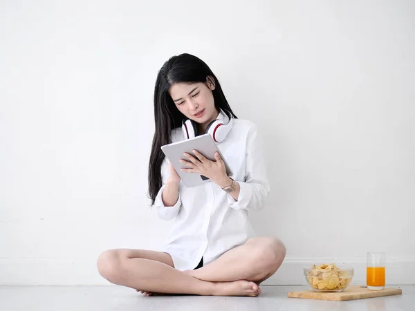 Mulher asiática bonita usando fone de ouvido e tablet no chão em — Fotografia de Stock