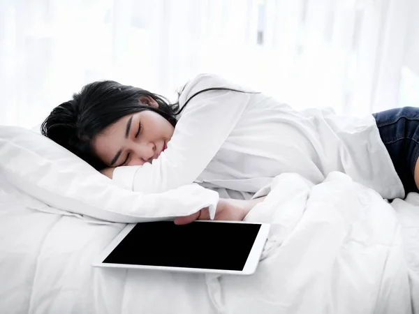Beautiful Asian woman sleeping on bed with tablet, lifestyle con — Stock Photo, Image