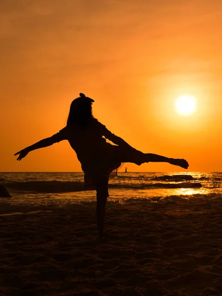 Silhueta menina dançando balé na praia ao nascer do sol . — Fotografia de Stock