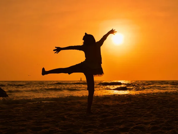 Silhueta menina dançando balé na praia ao nascer do sol . — Fotografia de Stock