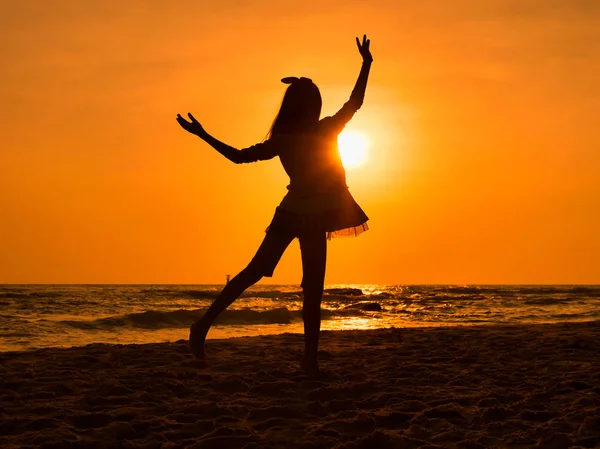 Silhueta menina dançando balé na praia ao nascer do sol . — Fotografia de Stock