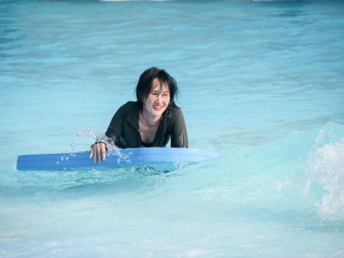 Asyalı kadın oyun dalga tahtası su Park, yaşam kavramı.